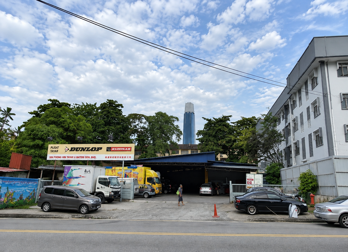 A professional, photorealistic image of a modern lorry and truck repair workshop in Malaysia.
